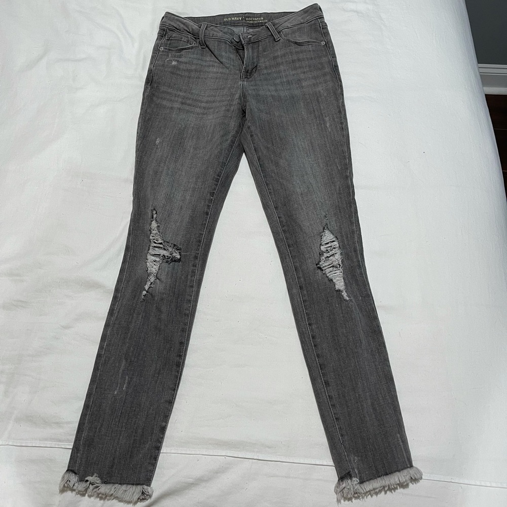 Old Navy mid rise grey skinny jeans with holes and frayed bottom. Size 6.